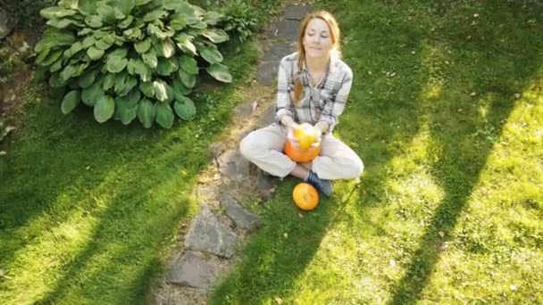 Mooie vrouw in de tuin met pompoenen — Stockvideo