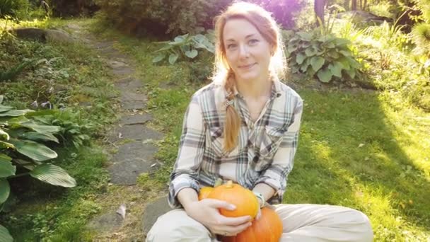 Hermosa mujer en el jardín con calabazas — Vídeos de Stock