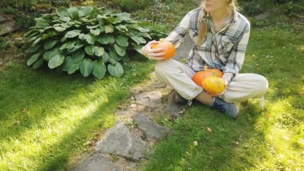 Mooie vrouw in de tuin met pompoenen — Stockvideo