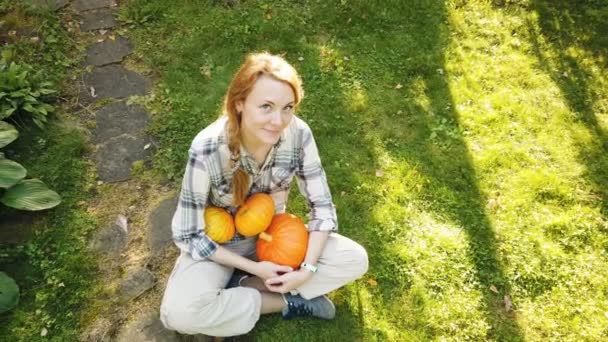 Schöne Frau im Garten mit Kürbissen — Stockvideo