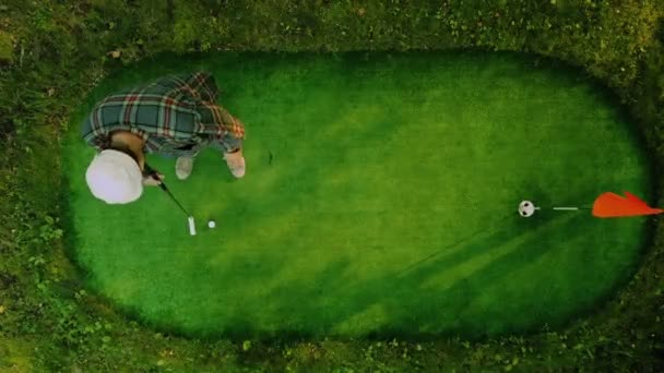 Giocatore di golf sta colpendo con successo la palla in vista dall'alto. Golfista in camicia a quadri — Video Stock