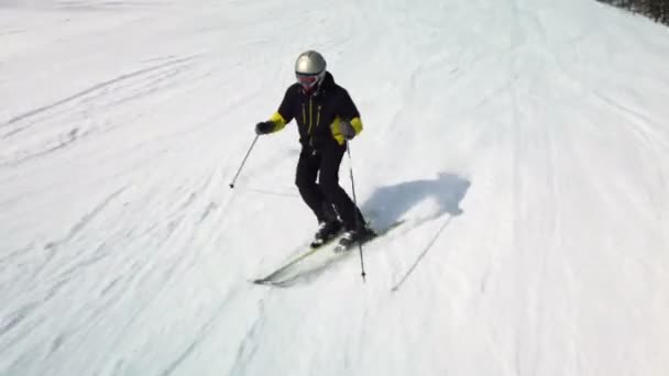 Genç yetişkin kayakçı soğuk kışta huzurlu ve mükemmel havanın tadını çıkarıyor. Kayak merkezindeki mükemmel hazırlanmış kayak pistinde tek başına kayak yapmak — Stok video