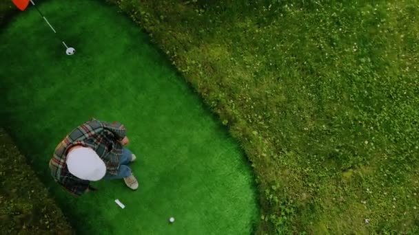 Boule de golf roule après tasse sur vert 