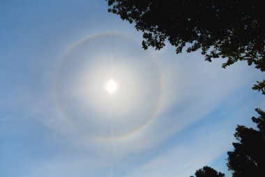 Sıcak yaz gününde güneşin etrafında atmosferik optik etki çemberi. Güneş etrafındaki atmosferik halo fenomeni