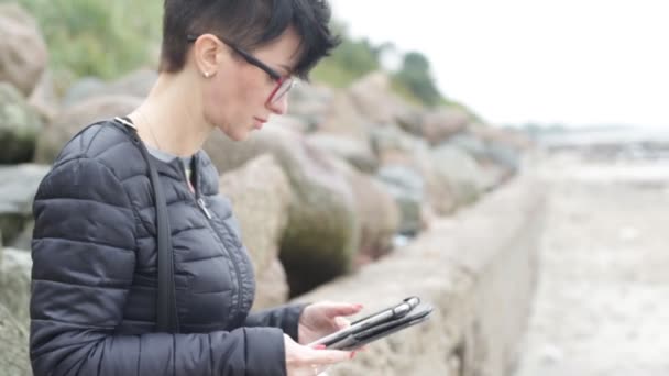 Uma Mulher Trabalha Seu Dia Folga Tablet Mar — Vídeo de Stock