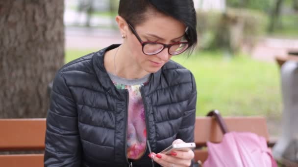 Una Chica Está Sentada Banco Con Café Escribiendo Mensaje Teléfono — Vídeo de stock