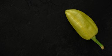 siyah beton dokulu sıva bir arka plan üzerinde sarı-yeşil jalapeno biber. İçerik veya reklam alanı içeren yaratıcı düzen şablonu