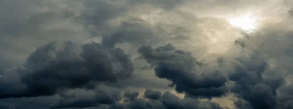 dramatic mystical sky with gray heavy clouds and faint back sunlight and lumen. artistic panoramic picture for the original background, layout or decoration