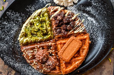 Ferrero Rocher, Nutella, Oreo, Lotus, Brownie, Pistachio, Çikolata, Krem şanti, Bıçak ve çatal ile servis edilen waffle.