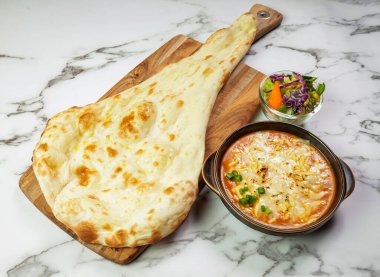 Hint kuzeninin mermer arka planına izole edilmiş peynirli köri soslu tavuk ve salata.