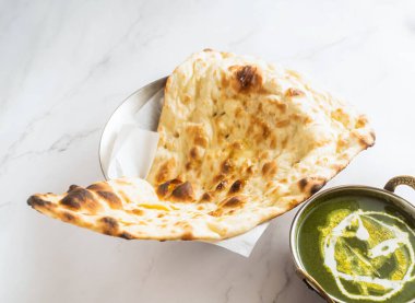 Tavuk Saag, Hint körili tavuk ve kremalı ıspanak. Pakistanlı kuzen Naan 'ın yakın çekim görüntüsüyle servis ediliyor.