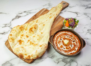 Dal Makhani ve Nan Ekmek ve Salata, Pakistanlı kuzenin mermer arka planda izole edilmiş.