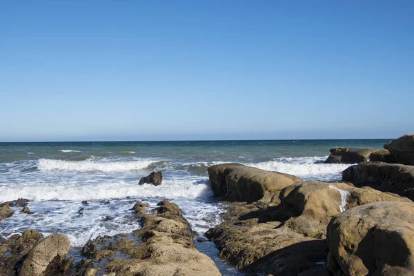 Deniz dalga köpüğü ve kayalar, Estepona, Endülüs, İspanya sahilinde. Huzurlu okyanus dalgalarının Beach. — Stok fotoğraf