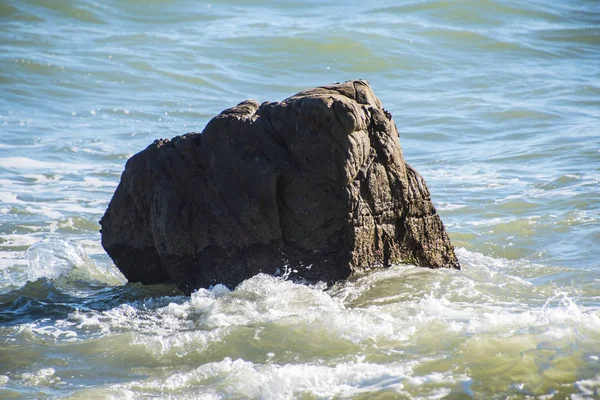 Meereswellen-Schaum und Felsen am Strand in Estepona, Andalusien, Spanien. friedliche Meereswellen am Strand. — Stockfoto