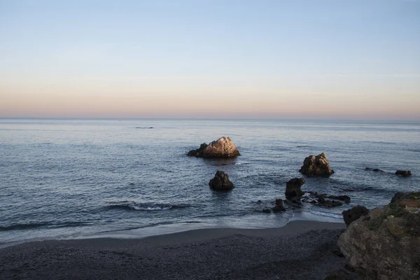 Deniz dalga köpüğü ve kayalar, Estepona, Endülüs, İspanya sahilinde. Huzurlu okyanus dalgalarının Beach. — Stok fotoğraf
