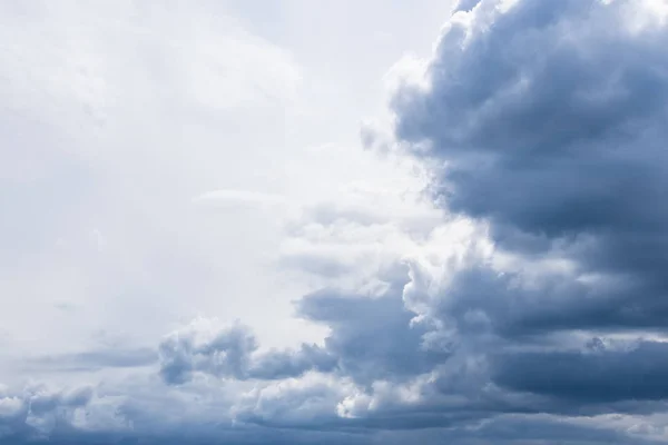 Dark thunder clouds on the blue sky. Abstract background with clouds on blue sky.