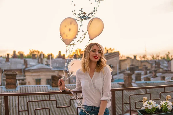 Glad flicka rymmer många ballonger på balkong eller tak — Stockfoto