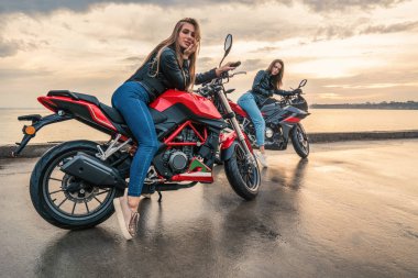 Deri ceket siyah ve kırmızı renk üzerinde'de iki motorcu kız motosiklet spor