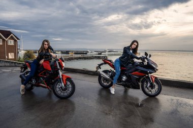 Deri ceket siyah ve kırmızı renk üzerinde'de iki motorcu kız motosiklet spor