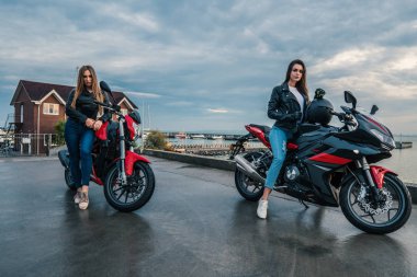 Deri ceket siyah ve kırmızı renk üzerinde'de iki motorcu kız motosiklet spor