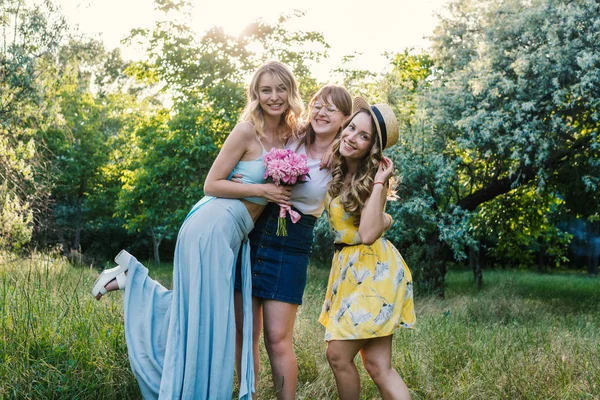 Três de meninas amigas ao ar livre no parque ou na floresta — Fotografia de Stock