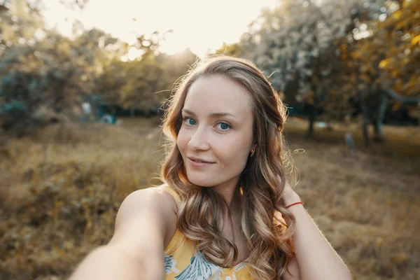 Stylowa dziewczyna nowoczesny biorąc selfie się w parku — Zdjęcie stockowe