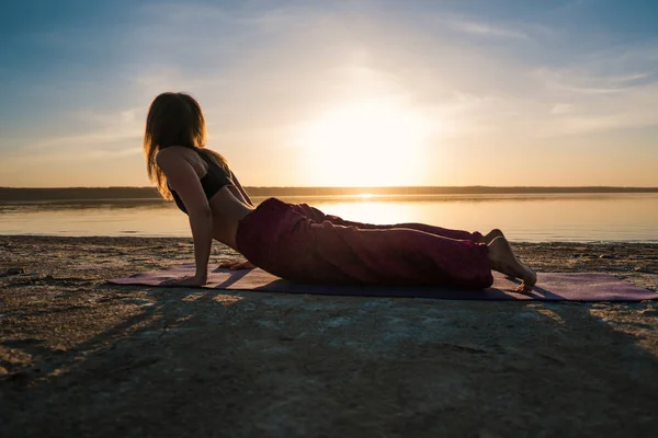 Silhouette yoga woman on the beach at sunset. — Stock Photo, Image