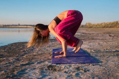 Gün batımında sahilde Yoga kadınla.