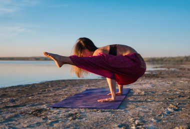 Gün batımında sahilde Yoga kadınla.