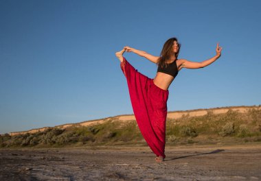 Gün batımında sahilde Yoga kadınla.