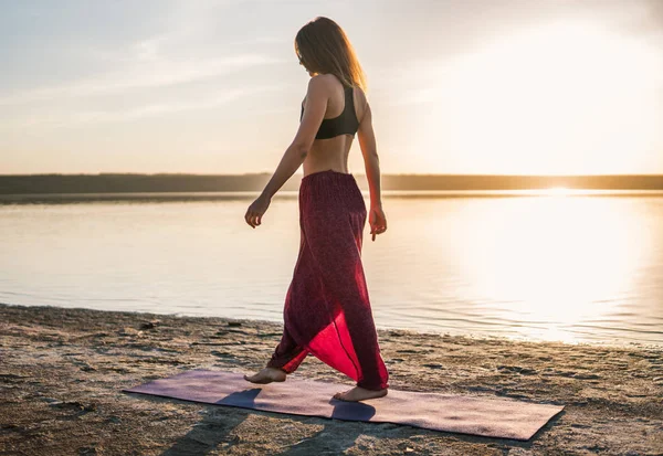 Жінка йога на пляжі на заході сонця . — стокове фото