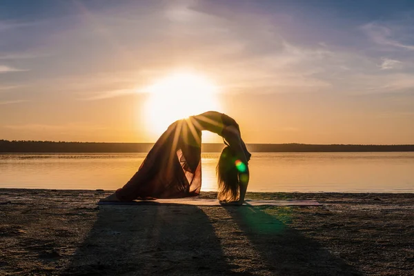 Silhouette Yoga-Frau am Strand bei Sonnenuntergang. — Stockfoto