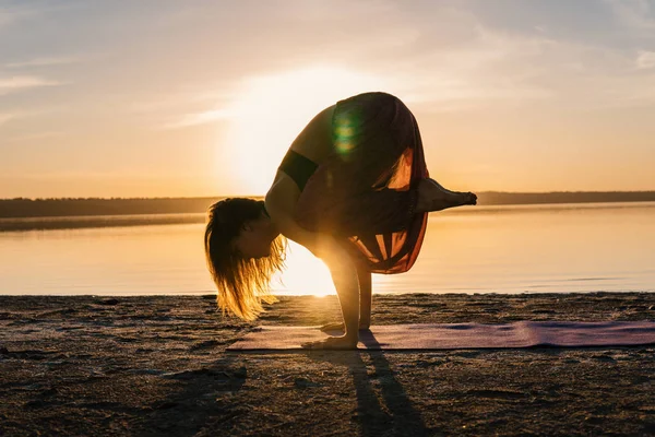 日落海滩上的剪影瑜伽女人. — 图库照片