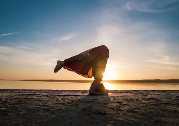 Σιλουέτα γυναίκα γιόγκα στην παραλία το ηλιοβασίλεμα. — Φωτογραφία Αρχείου