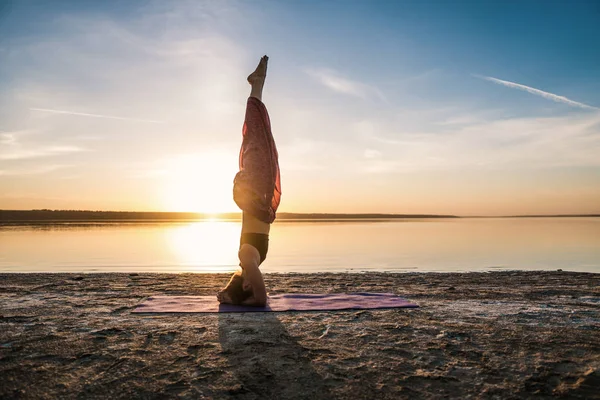 Silhouette yoga woman on the beach at sunset. — Stock Photo, Image