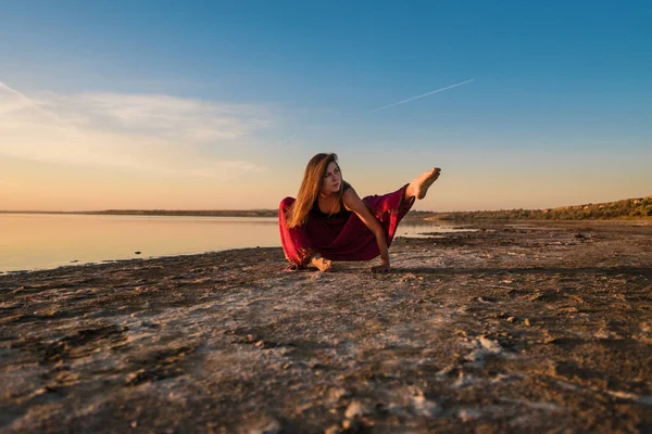 Mujer del yoga en la playa al atardecer . — Foto de Stock