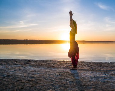 Gün batımında sahilde Yoga kadınla.