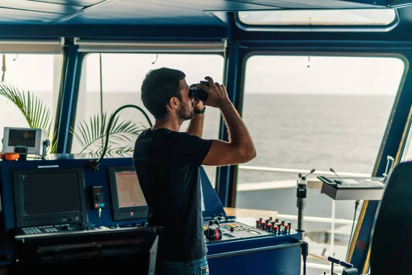 Navigointiupseeri katselee navigointivahtia kiikarien läpi — kuvapankkivalokuva
