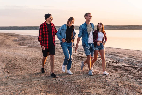 Amigos en la playa juntos caminando al atardecer — Foto de Stock