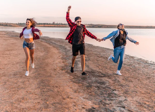 Jóvenes amigos hipster en la playa corriendo juntos — Foto de Stock