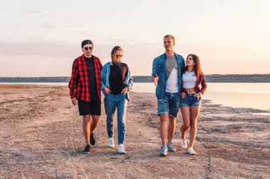 birlikte yürüyüş sırasında sunset beach üzerinde arkadaşlar