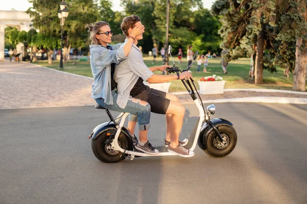 Preciosa joven feliz pareja conduciendo bicicleta eléctrica — Foto de Stock
