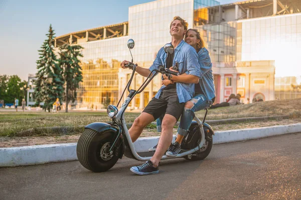 Szép fiatal pár vezetés elektromos kerékpár, nyáron — Stock Fotó