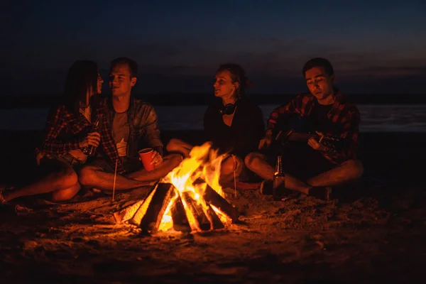 Junge Freunde picknicken mit Lagerfeuer am Strand — Stockfoto