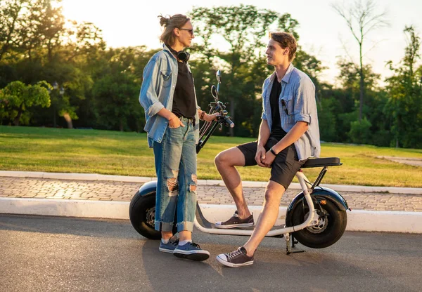 Preciosa joven feliz pareja con bicicleta eléctrica —  Fotos de Stock