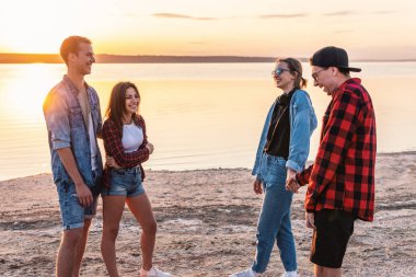 birlikte yürüyüş sırasında sunset beach üzerinde çift arkadaşlar
