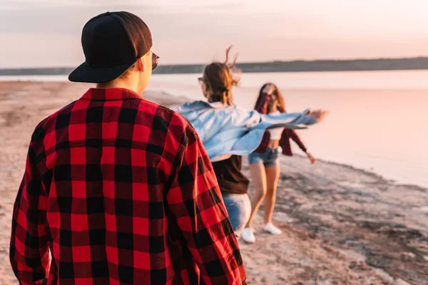 Amigos en la playa juntos caminando al atardecer — Foto de Stock