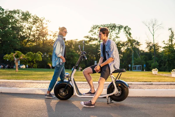 Preciosa joven feliz pareja con bicicleta eléctrica —  Fotos de Stock