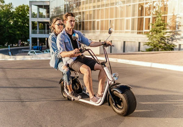 Preciosa joven feliz pareja conduciendo bicicleta eléctrica —  Fotos de Stock