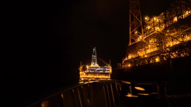 FPSO tankowiec statku w pobliżu platforma Oil Rig w nocy. Offshore przemysłu ropy naftowej i gazu — Wideo stockowe
